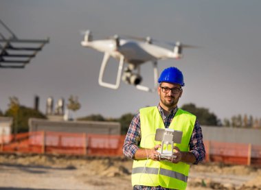 Mühendis dron site oluşturma, uzaktan kumandasındaki ile kask ile portresi