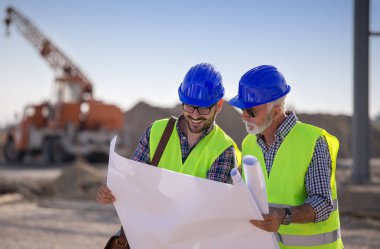 Site inşaat teknik arka planda Bina, planları bakarak iki memnun mühendisleri 