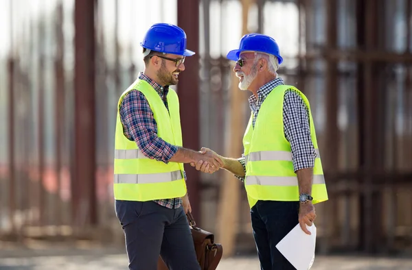 Dois Engenheiros Apertando Mão Local Construção Com Construção Metal Fundo — Fotografia de Stock