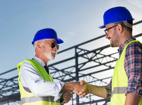 Zwei Ingenieure Beim Händeschütteln Auf Einer Baustelle Mit Metallkonstruktion Hintergrund — Stockfoto