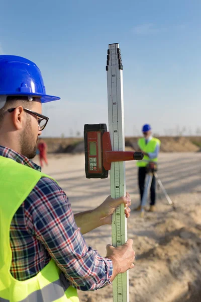 Bauarbeiter Hält Laser Messwerkzeug Auf Baustelle — Stockfoto