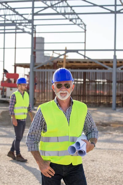 Engenheiro Sénior Segurando Plantas Frente Estrutura Metálica Canteiro Obras — Fotografia de Stock