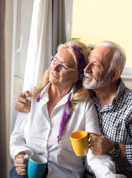 Feliz Pareja Ancianos Pie Junto Ventana Mirando Hacia Fuera — Foto de Stock