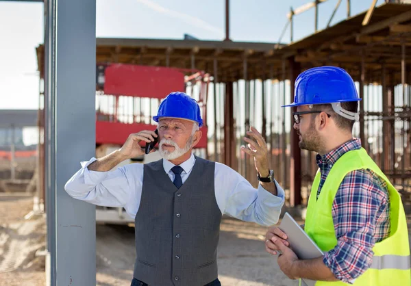 Wütender Senior Ingenieur Mit Helm Telefoniert Neben Jungem Arbeiter Auf — Stockfoto