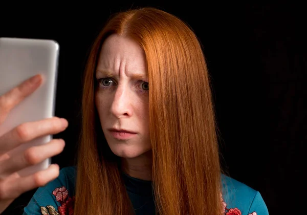 Angry Redhead Girl Looking Mobile Phone Black Background — Stock Photo, Image