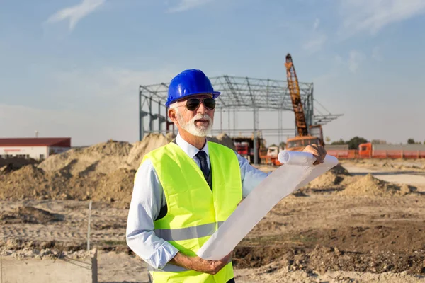 Oberingenieur Betrachtet Baupläne Vor Metallkonstruktion Auf Baustelle — Stockfoto