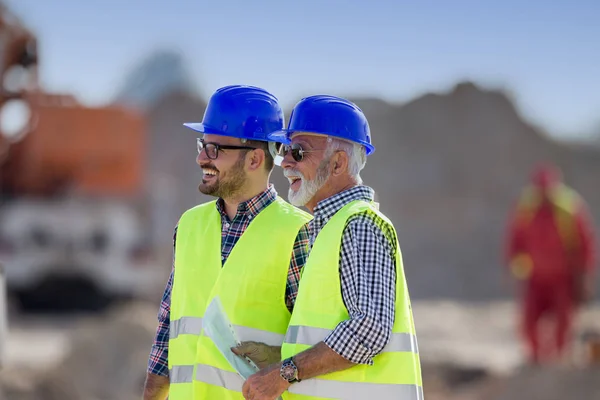 Zwei Zufriedene Ingenieure Unterhalten Sich Auf Der Baustelle Mit Baumaschinen — Stockfoto