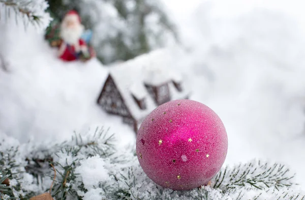 雪やバック グラウンドでコテージまで歩くサンタ クロースとツリーのカバーにクリスマス飾りのクローズ アップ — ストック写真