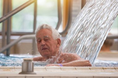 Yaşlı adam ile sıcak su havuzunda zevk ve spa resort duşta Masaj