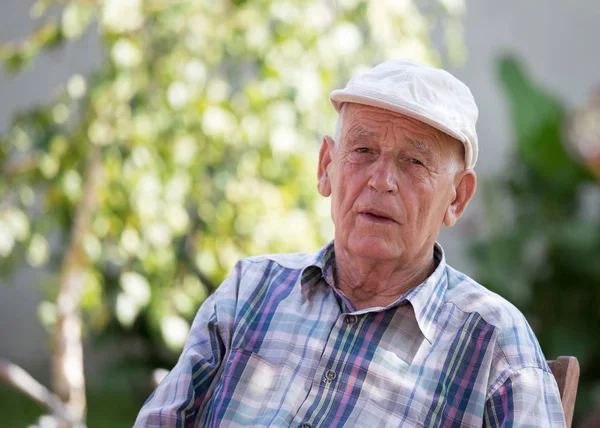 Портрет Пожилого Человека Кепке Сидящего Парке Зеленым Деревом Заднем Плане — стоковое фото