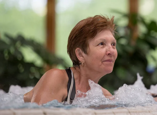 在水疗度假村的热水池里享受的老年妇女 — 图库照片