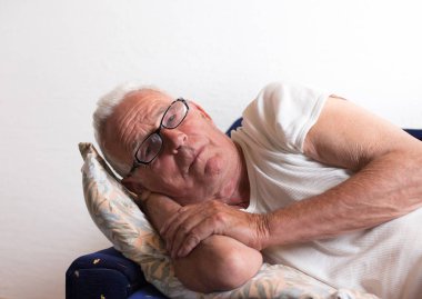 İhtiyar yan koltukta yatan ve oturma odasında dinleniyor