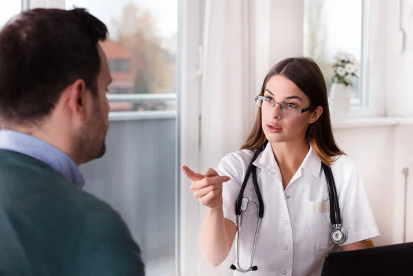 Unga Kvinnliga Läkare Förklara Något För Patient Skrivbord Kliniken Office — Stockfoto