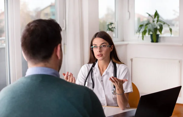 Unga Kvinnliga Läkare Förklara Något För Patient Skrivbord Kliniken Office — Stockfoto