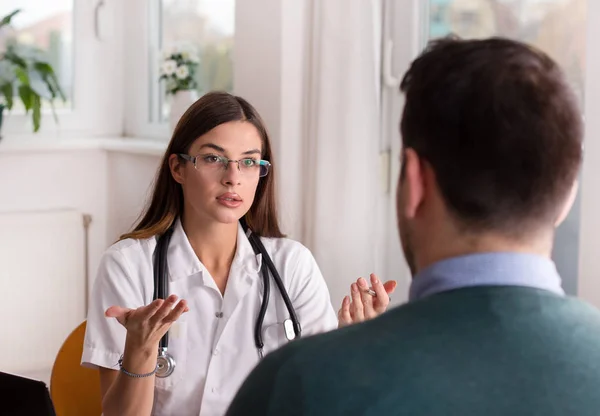 Doctor and patient talking at table — Stock Photo, Image