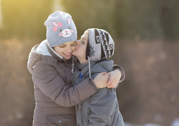 Kinder küssen sich im Park im Schnee — Stockfoto