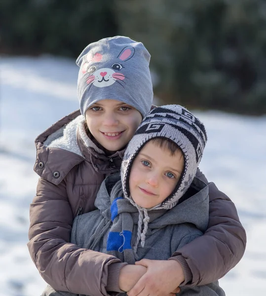 Kinder umarmen sich im Schnee — Stockfoto