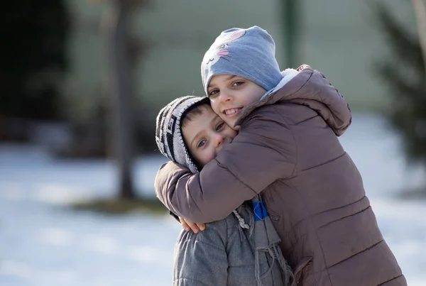 Děti objímají sníh — Stock fotografie
