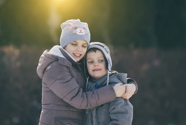 Kinder umarmen sich im Schnee — Stockfoto