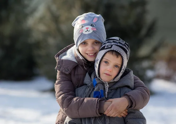 Kinder umarmen sich im Schnee — Stockfoto