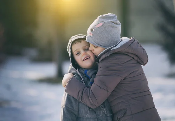 Kinder umarmen sich im Schnee — Stockfoto