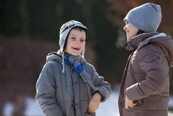 Junge und Mädchen auf Schnee im Park — Stockfoto
