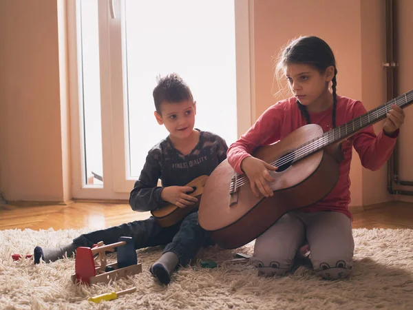 Enfants jouant de la guitare sur tapis — Photo