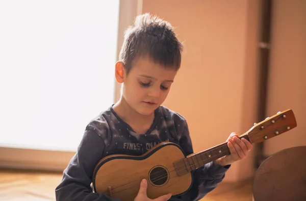 Chłopiec ciesząc się grając na gitarze — Zdjęcie stockowe