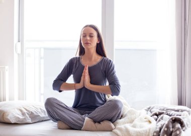 Yatakta yoga yapan kız