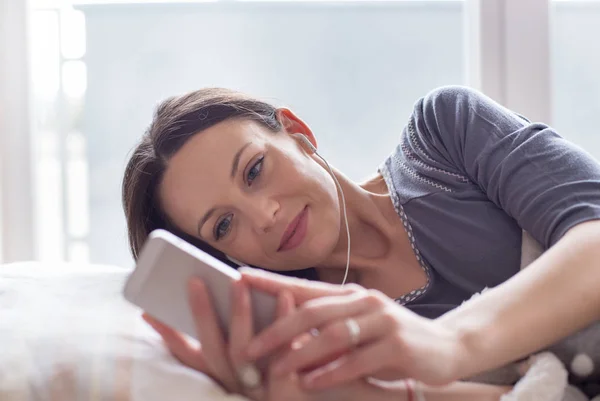 Mädchen hört Musik im Bett — Stockfoto