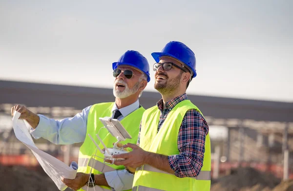 Construction engineers with drone at building site