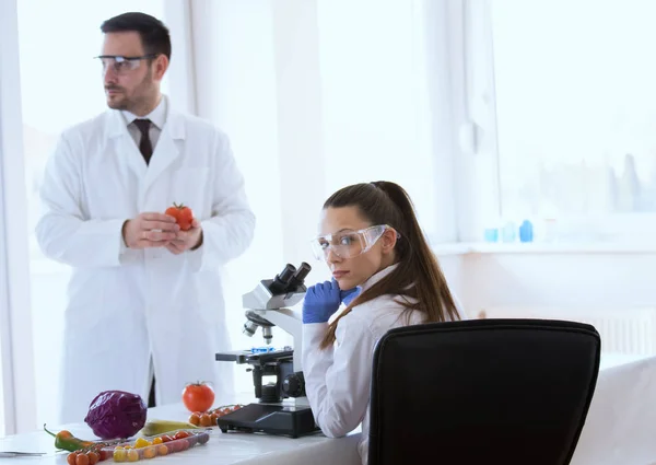 Ученые с овощами в лаборатории — стоковое фото