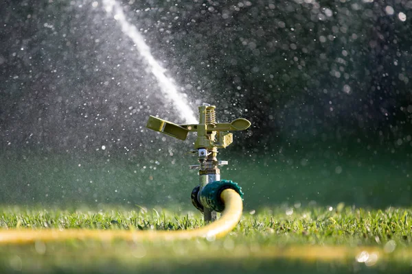 Sistem irigasi di lapangan rumput di kebun — Stok Foto