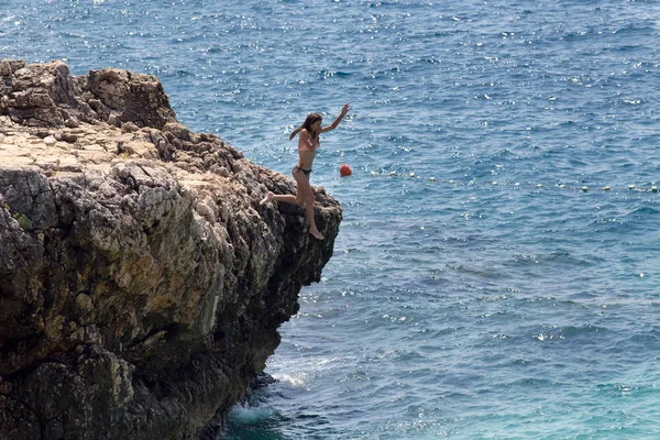 Girl jumping in water from cliff Royalty Free Stock Photos