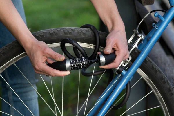 Woman locking bicycle with combination lock — Stock Photo, Image