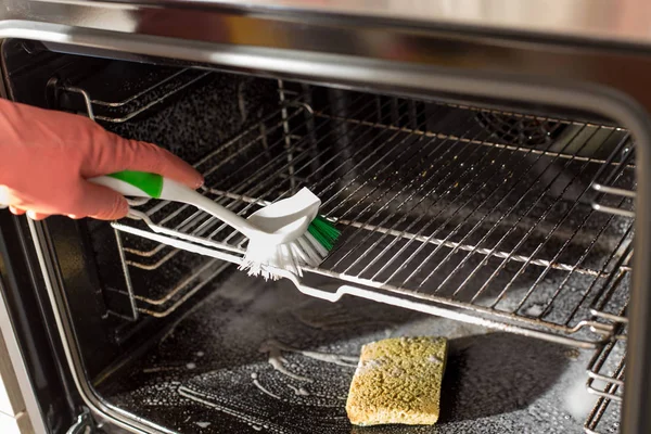 Woman cleaning oven — Stock Photo, Image