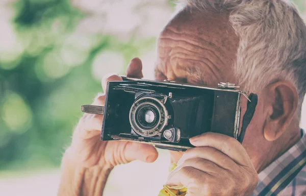 Старик с аналоговой камерой — стоковое фото