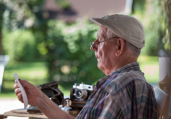 Uomo anziano guardando vecchie foto — Foto Stock