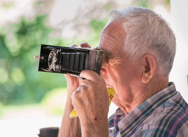 Oude man met analoge camera — Stockfoto