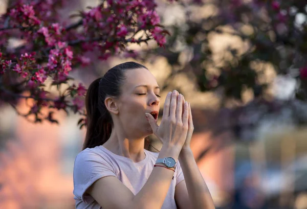 Vrouw niezen vanwege voorjaar stuifmeel allergie — Stockfoto