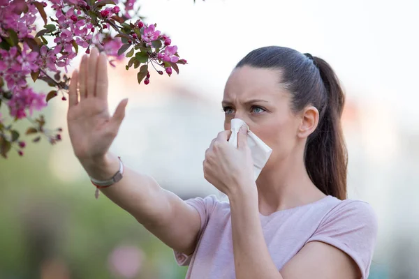 Wanita menunjukkan tanda berhenti untuk alergen di taman — Stok Foto