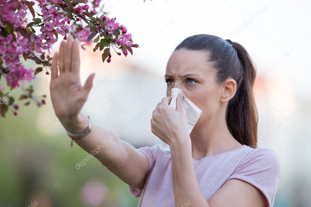 Woman showing stop sign to allergens in park