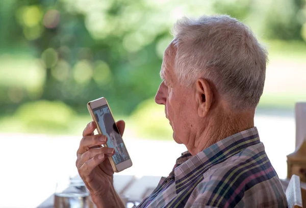 Старик разговаривает по мобильному телефону — стоковое фото