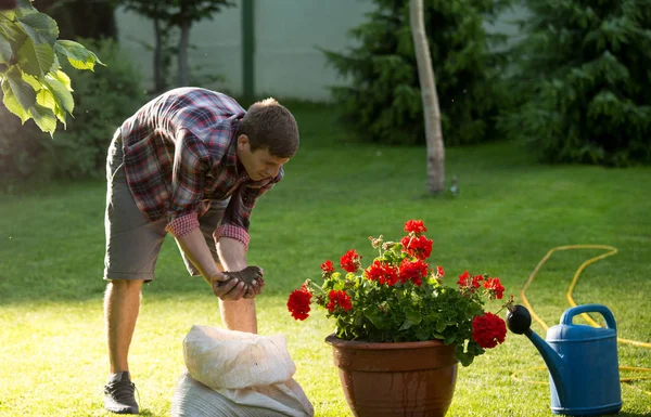 Człowiek doniczkowania kwiatów w ogrodzie — Zdjęcie stockowe
