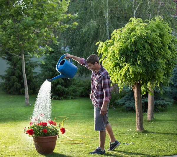 El hombre regando las plantas en el jardín — Foto de Stock
