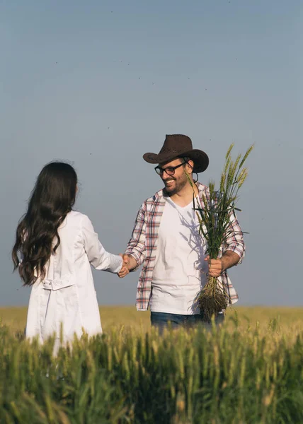 Agricultor y agrónomo estrechando manos en el campo — Foto de Stock