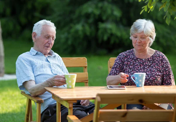 Oude paar drinken thee in Park — Stockfoto