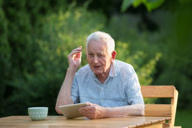 Bahçede tablet ile Kıdemli adam