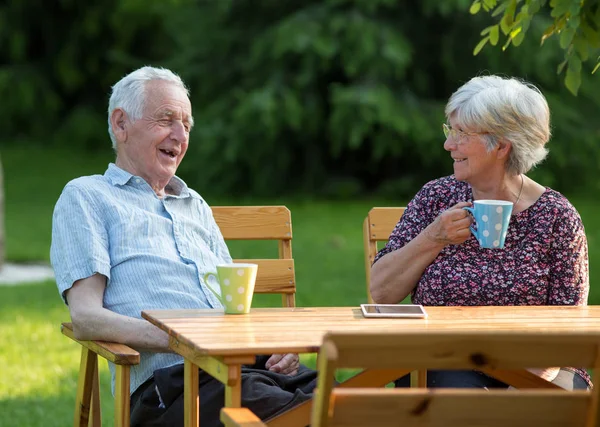 Old couple drinking tea in park — Stock Photo, Image