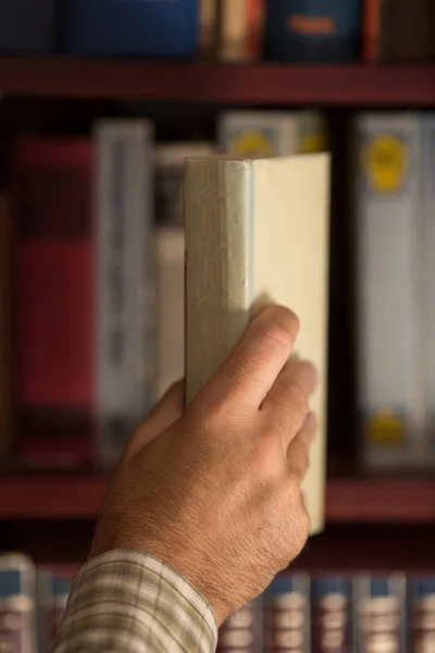 Man putting book on shelf — Stock Photo, Image